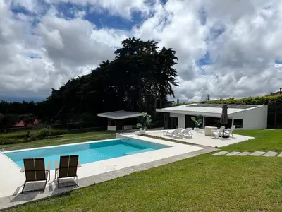 a swimming pool with chairs and a house at AO Buena Vista Home - Panoramic View in Concepción