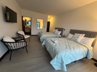 a bedroom with two beds and a chair at AO Buena Vista Home - Panoramic View in Concepción