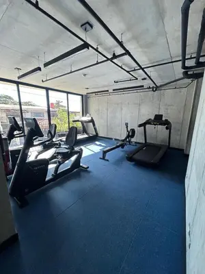 a gym with treadmills and ellipticals in a room at Chill Lodge Babylon Tower 506 in San José