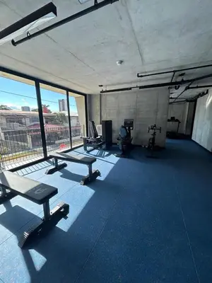 a gym with treadmills and chairs in a building at Chill Lodge Babylon Tower 506 in San José