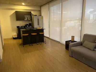 a living room with a couch and a kitchen at Chill Lodge Babylon Tower 506 in San José