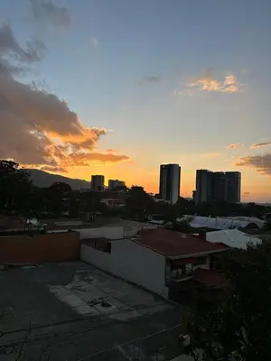 a view of a city at sunset with buildings at Chill Lodge Babylon Tower 506 in San José