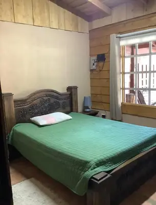 a bedroom with a green bed with a window at Poasito Room in Fraijanes