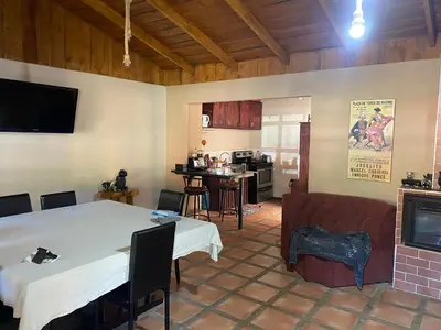a living room with a white table and a kitchen at Poasito Room in Fraijanes