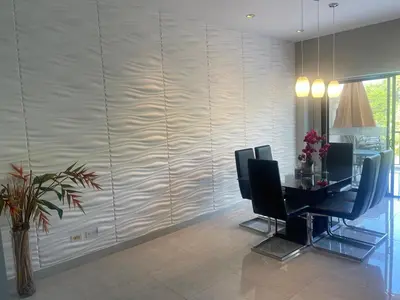 a room with a table and chairs and a wall at Jacobay condominio 3303 in Jacó