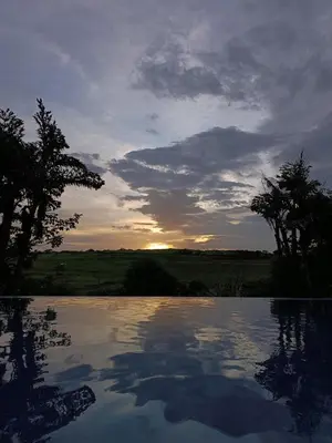 a sunset over a pool of water with the sun setting at SJO - Casa Taccari in Grecia