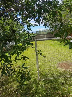 a fence in the grass with a soccer field at SJO - Casa Taccari in Grecia