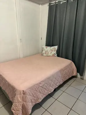 a small bed in a room with green curtains at Hospedaje Loma Verde in Chiles