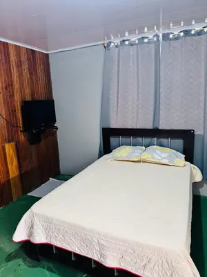 a bedroom with a bed and a television in it at Hospedaje Loma Verde in Chiles
