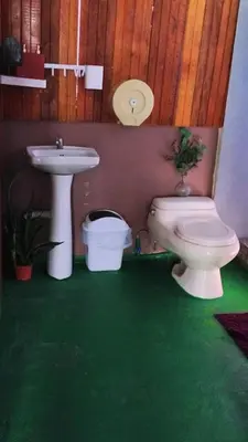 a bathroom with a toilet and a sink at Hospedaje Loma Verde in Chiles
