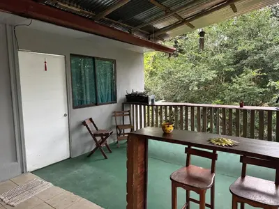 a porch with a table and chairs on a patio at Hospedaje Loma Verde in Chiles