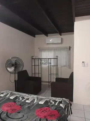 a bedroom with a bed and a fan at Small blue house in Quepos