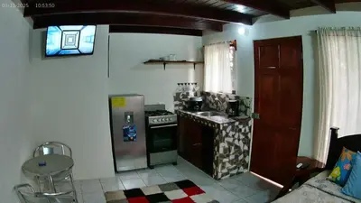 a kitchen with a stove and a refrigerator at Small blue house in Quepos