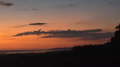 a sunset on a beach with the ocean at WAVESCRhouse1 in Parrita