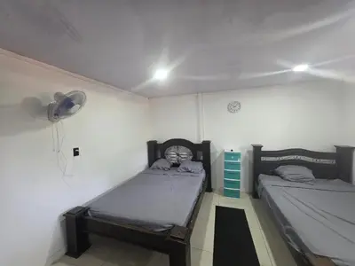 a bedroom with two twin beds and a fan at WAVESCRhouse1 in Parrita