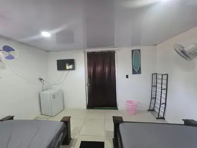 a room with two beds and a brown door at WAVESCRhouse1 in Parrita
