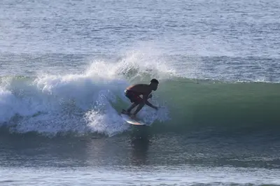 a man riding a wave on a surfboard in the ocean at WAVESCRhouse1 in Parrita
