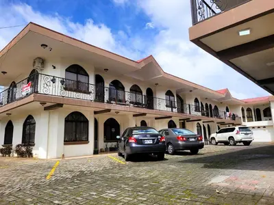 a building with cars parked in a parking lot at Arenal Mountain Apartments in Fortuna