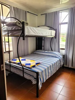 two bunk beds in a room with a window at Arenal Mountain Apartments in Fortuna