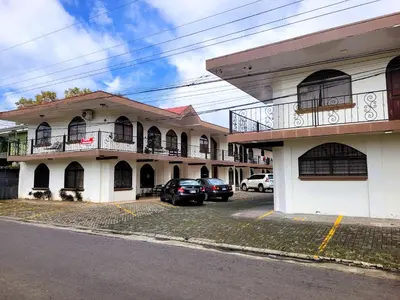 a building with cars parked in front of it at Arenal Mountain Apartments in Fortuna