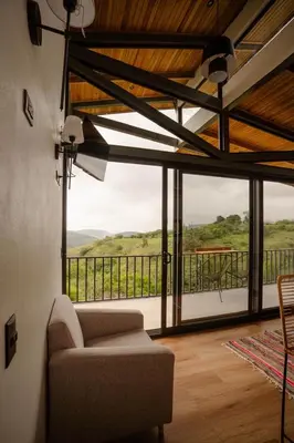 a living room with a couch and a large window at BìBO Horizon House in Monteverde Costa Rica
