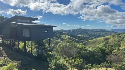 a house on the side of a hill with mountains at BìBO Horizon House in Monteverde Costa Rica