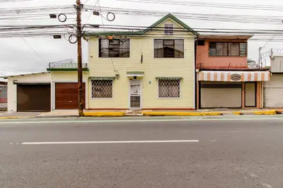 a yellow house on the side of a street at Vilma Friendly Guesthouse - RC in San José