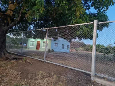 a chain link fence in front of a house at Nayon Vacation Home in Portegolpe