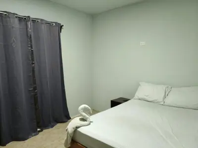 a bedroom with a bed with black curtains at Nayon Vacation Home in Portegolpe
