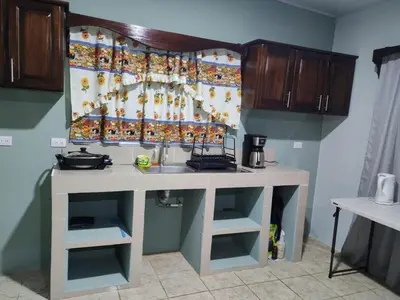 a kitchen with a sink and a counter top at Nayon Vacation Home in Portegolpe