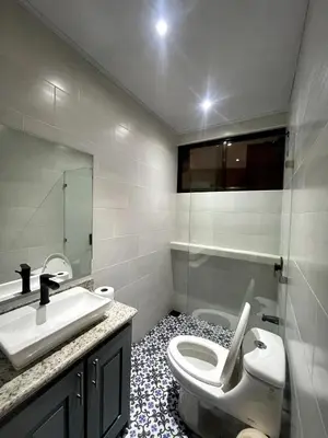 a bathroom with a white toilet and a sink at Casa Blue in Brasilito