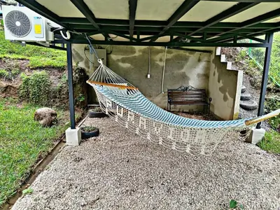 a hammock is hanging from a pergola at The Chicken House in El Castillo de La Fortuna