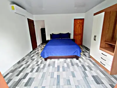 a bedroom with a bed with a blue comforter at The Chicken House in El Castillo de La Fortuna