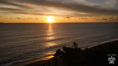 a sunset over the ocean with the sun setting at Casa Shec- An Oceanfront Jungle Retreat in Drake