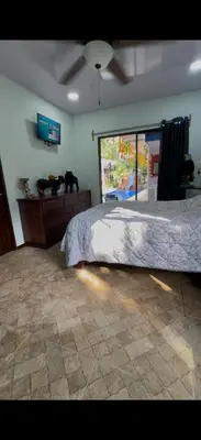 a bedroom with a bed and a ceiling fan at Casa Tres Diamantes 6pax, Pool, AC, WIFI in Parrita