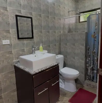 a bathroom with a sink and a toilet at Casa Tres Diamantes 6pax, Pool, AC, WIFI in Parrita