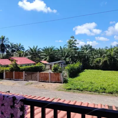 a view from the balcony of a house with a yard at Casa Tres Diamantes 6pax, Pool, AC, WIFI in Parrita