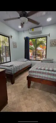 a room with two beds and a ceiling fan at Casa Tres Diamantes 6pax, Pool, AC, WIFI in Parrita
