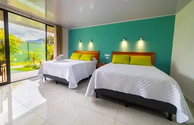 a bedroom with two beds and a blue wall at Hotel Secreto La Fortuna in Fortuna