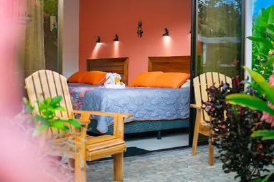 a bedroom with a bed and two chairs at Hotel Secreto La Fortuna in Fortuna