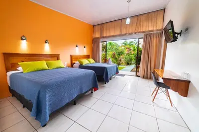 a bedroom with two beds and a television in it at Hotel Secreto La Fortuna in Fortuna