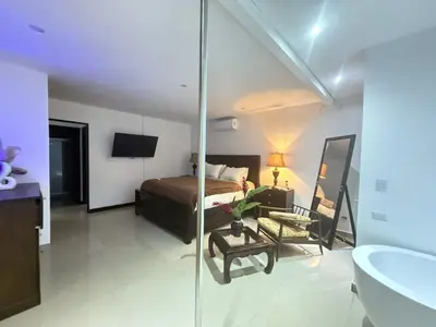 a bedroom with a bed and a bathroom with a mirror at Encantadora casa con piscina privada in Herradura