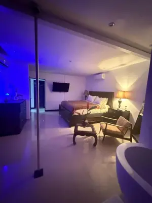 a bedroom with a bed and a couch and a tv at Encantadora casa con piscina privada in Herradura