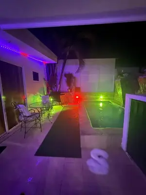 a backyard with a pool at night with lights at Encantadora casa con piscina privada in Herradura