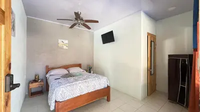 a bedroom with a bed and a ceiling fan at Tres Diamantes hotel in Parrita