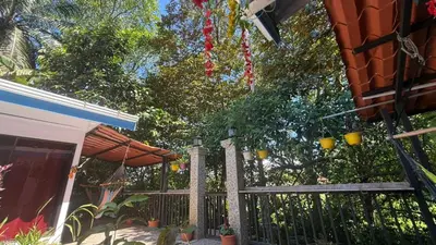 a fence in front of a house with an umbrella at Tres Diamantes hotel in Parrita