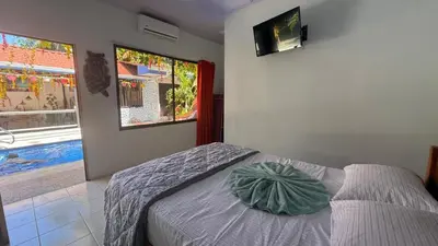 a bedroom with a bed and a swimming pool at Tres Diamantes hotel in Parrita