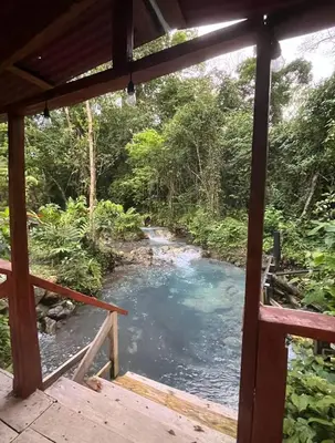 a view of a river from a porch at Mineral River Eco Village in Tapantí