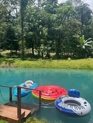 three inflatable boats are tied to a dock in the water at Mineral River Eco Village in Tapantí