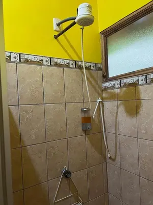 a shower in a bathroom with a yellow wall at Cabañas Luz de Luna